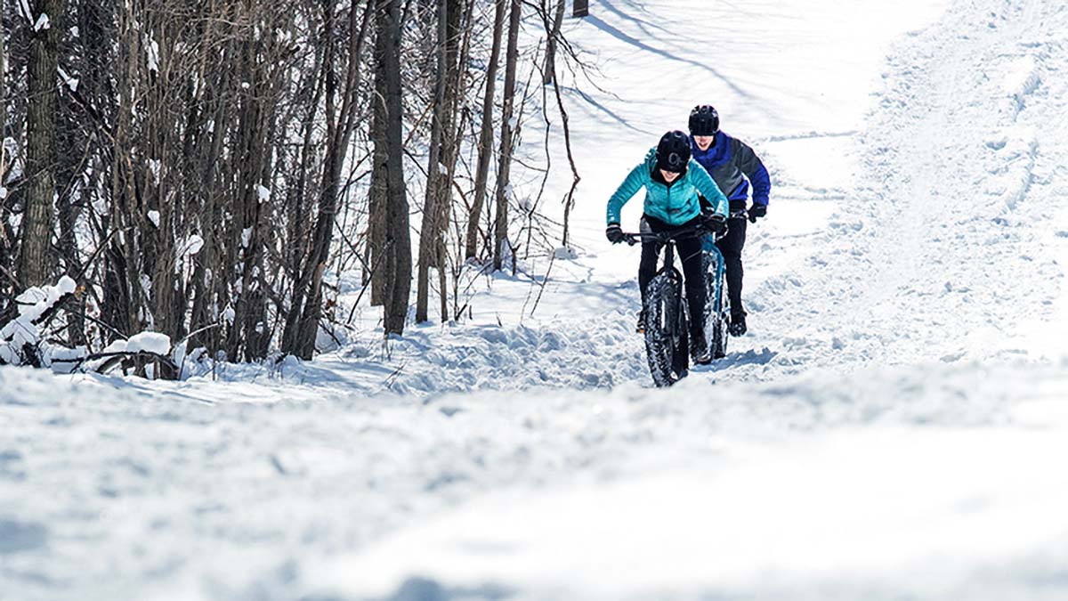 02042 Drinking Hot Liquids In Cold Weather A Female And Male Fatbiker Ride Through A Snow Field