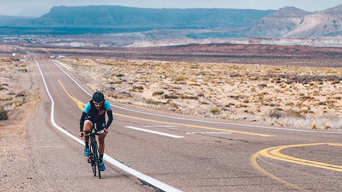 Here Are Five Easy Ways To Increase Cycling Power Image Of A Cyclist Riding On Desert Road To Increase Cycling Power