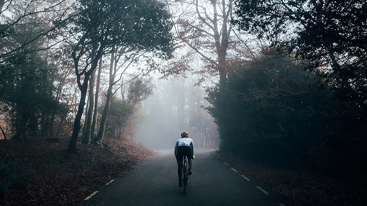 11279 Winter Cycling Workouts For Building An Aerobic Base A Cyclist Riding On A Road Through A Forest With Fog