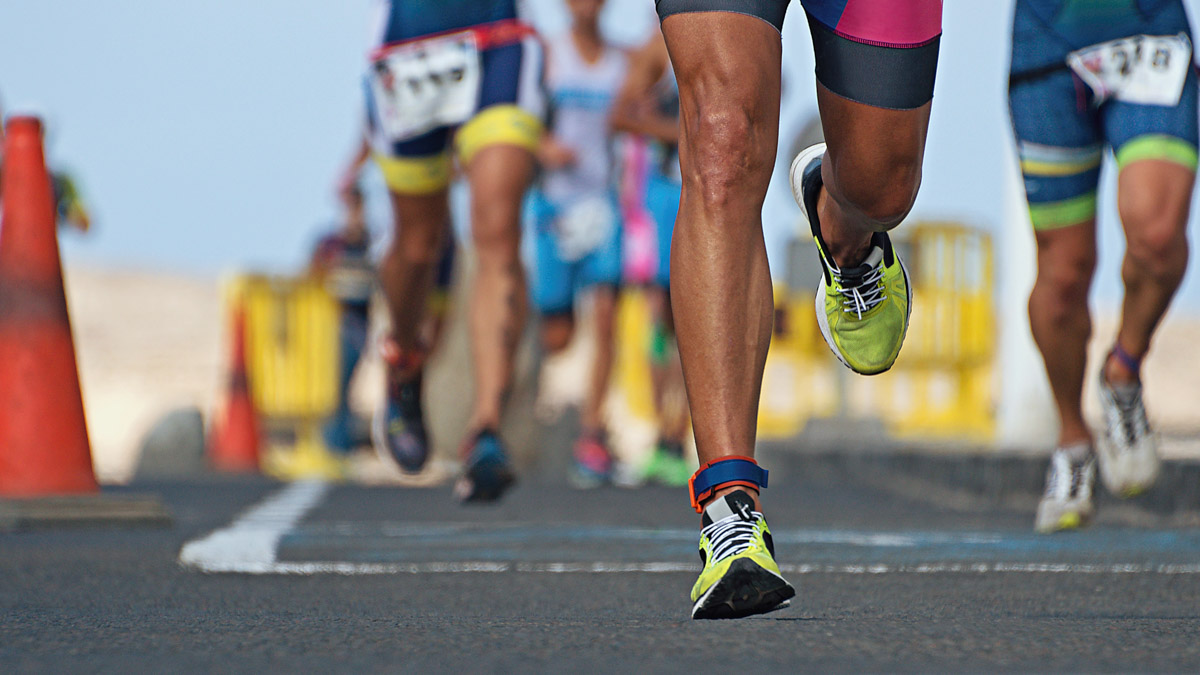 Training For An Ironman With Better Time Management Fit Runner's Legs With Yellow Running Shoes Racing In Ironman